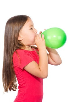 Mädchen spielt auf dem Kindergeburtstag mit Luftballon