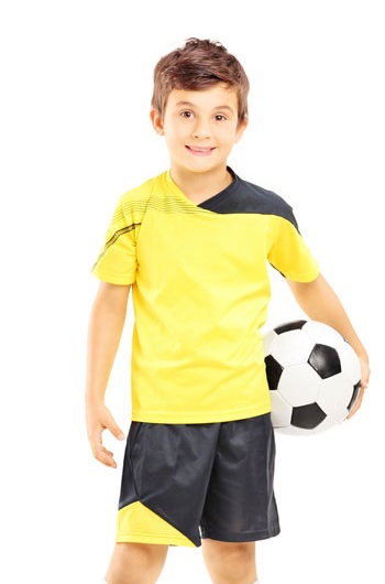Kind mit Ball im Fußball-Trikot